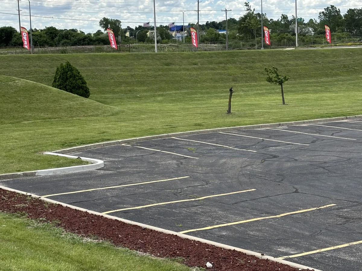 Fresh red mulch installed in a curbside bed with a cut edge holding the line against the lawn